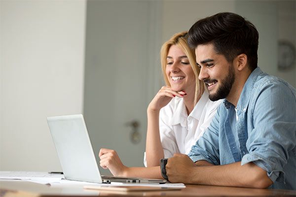 Couple sitting in front of laptop